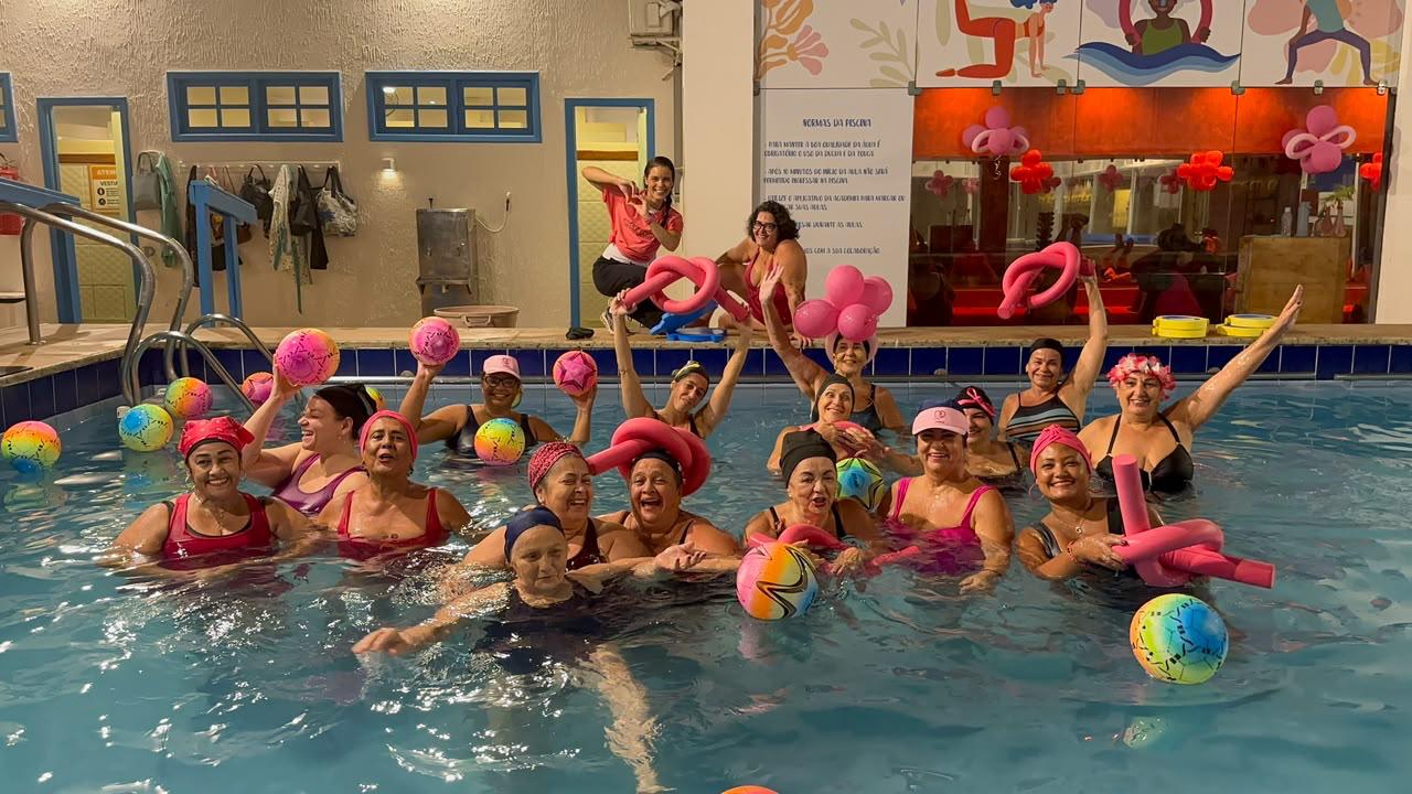 Turma da noite da Academia Andréa Maestri celebra o Outubro Rosa na piscina com bolas e balões