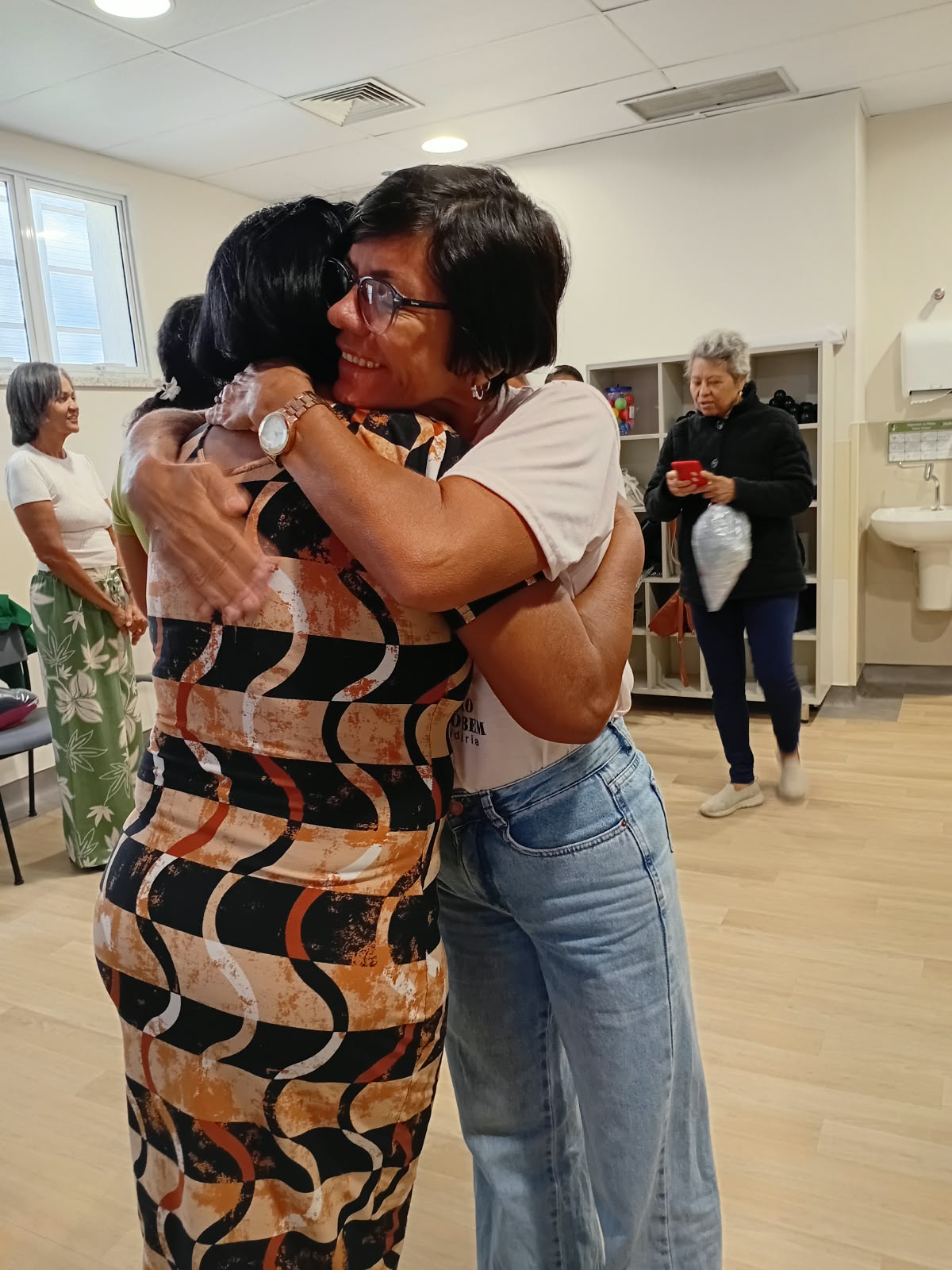 Voluntária da ASBEM abraça paciente durante a entrega de almofadas de coração