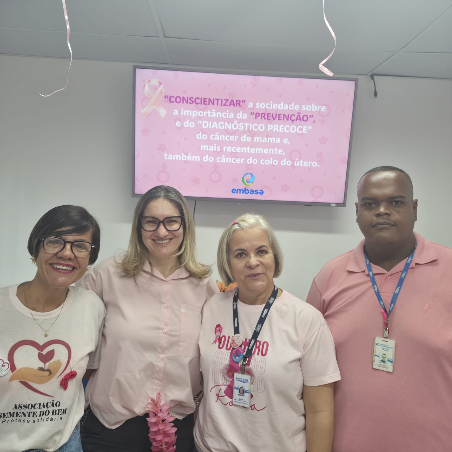 Representantes da ASBEM e da Embasa em frente ao telão sobre prevenção e diagnóstico precoce do câncer de mama