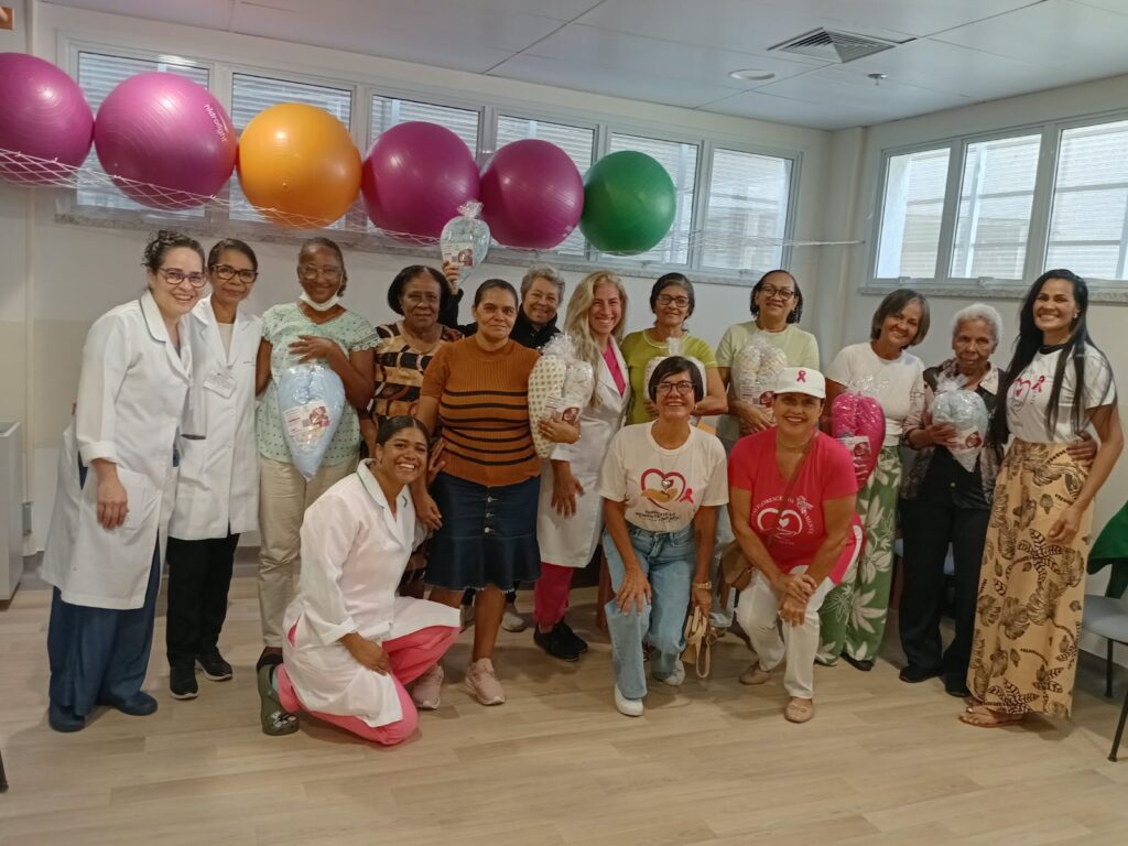 Pacientes, profissionais de saúde e voluntárias da ASBEM reunidas com almofadas de coração no Hospital Aristides Maltez
