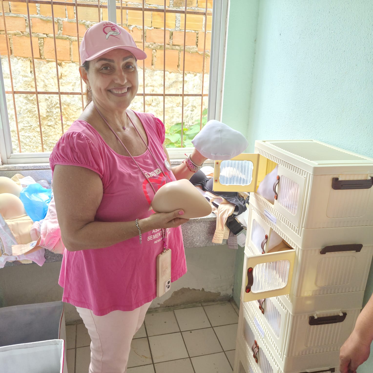 Voluntária da ASBEM mostra prótese mamária externa do Programa Mama Solidária
