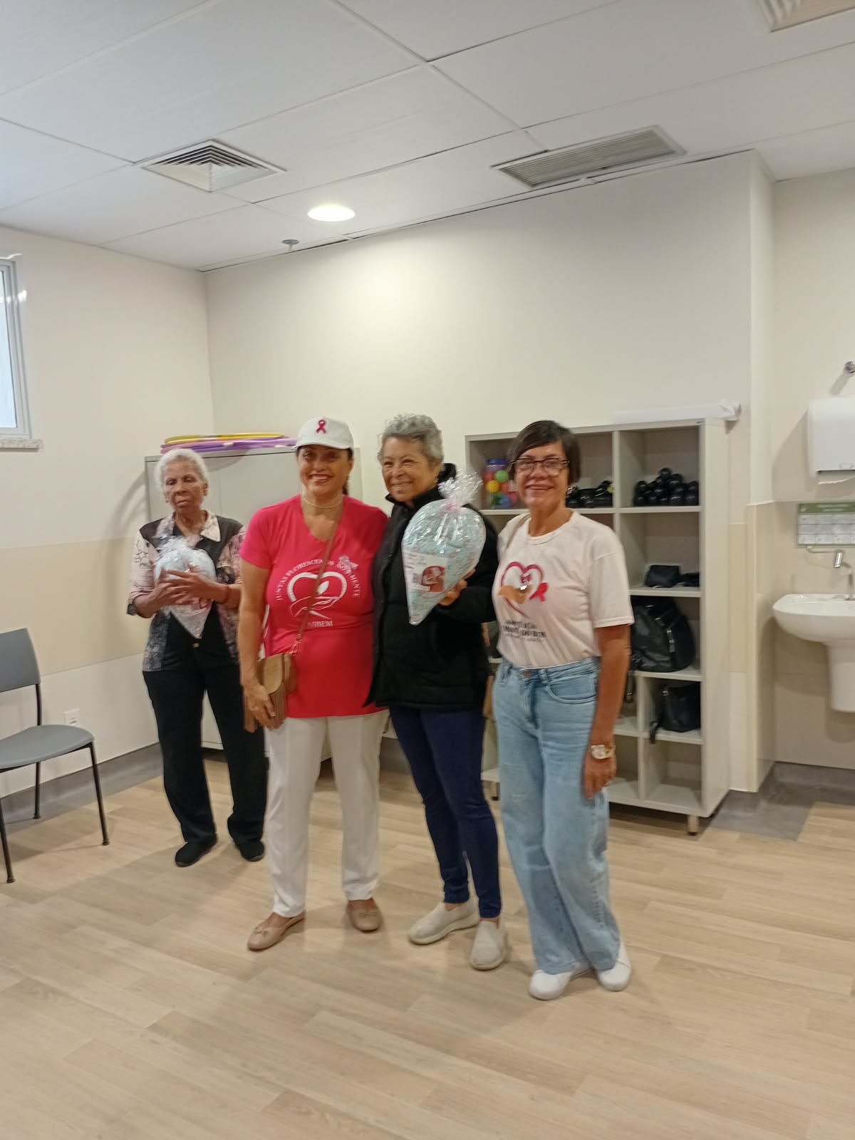 Voluntárias da ASBEM ao lado de pacientes que receberam almofadas de coração